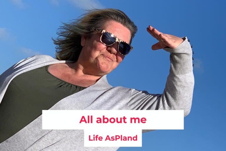 Debs aspland wearing sunglasses and a grey jacket looking out to sea