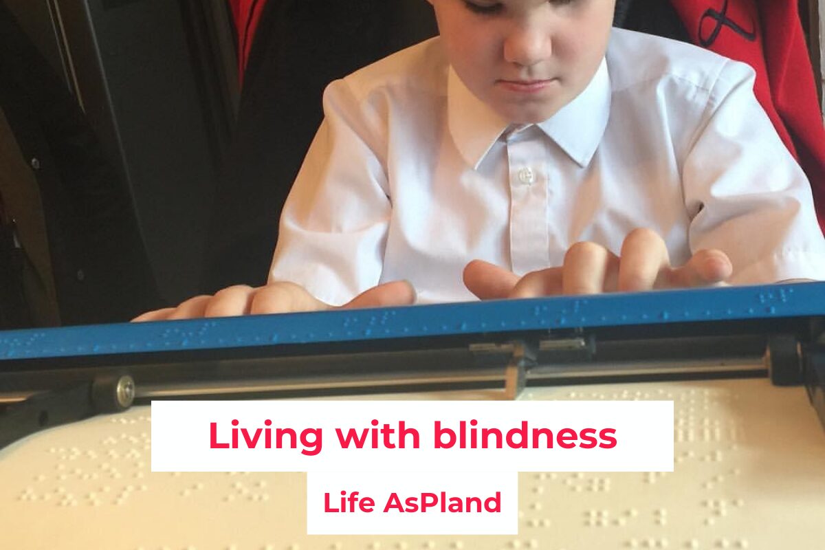 Young boy sat at a table using a Mountbatten braille machine